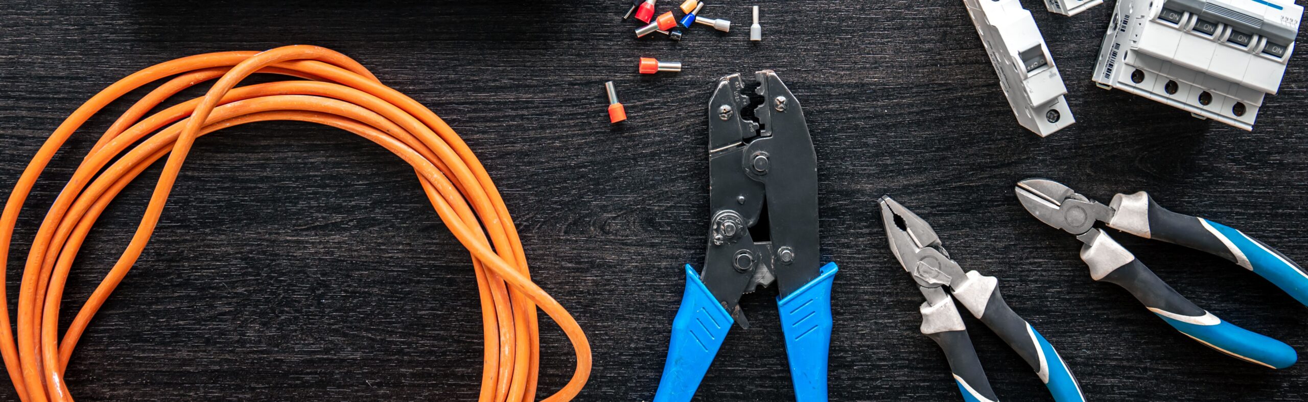 Different electrical tools and digital tablet on wooden background, flat lay.